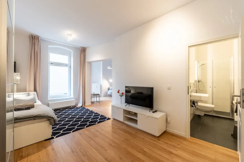 Bett, Teppich und ein Fernseher mit einem Schrank sind auf dem Bild