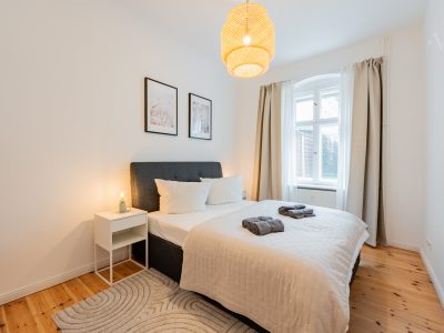 Minimalistisches Schlafzimmer mit Doppelbett, Naturtönen und Tageslicht