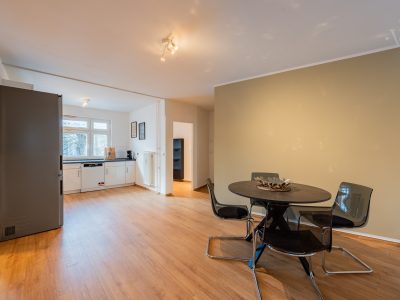 Essbereich mit rundem Tisch und offener Küche in einem großzügigen Apartment