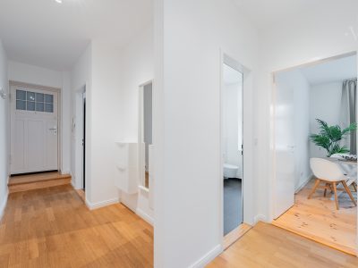 Heller Flur mit Parkettboden und Zugang zu weiteren Zimmern im Apartment