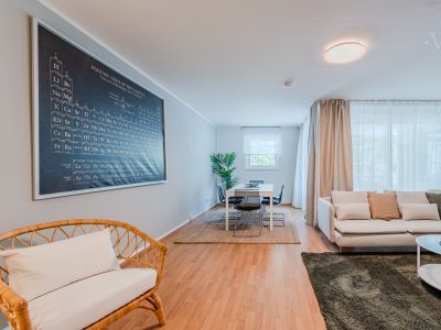 Lichtdurchfluteter Wohnbereich mit großem Wandbild und bequemer Sitzgruppe