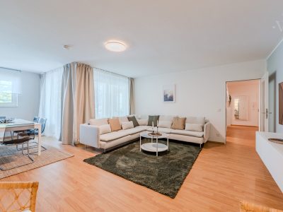 Gemütliche Sitzecke mit Vorhängen, Couchtisch und grünem Teppich