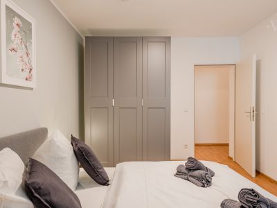 Schlafzimmer mit großem Kleiderschrank und stilvoll gefaltetem Bettzeug