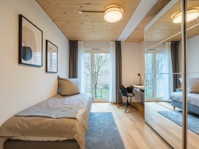 Wohnbereich mit Schlafsofa und Zugang zur Terrasse – lichtdurchflutetes Apartment